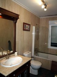 baño con paredes travertino romano y suelo granito brasileño