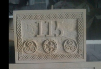 placa numeración con cenefa celta y trisqueles en alto relieve en arenisca floresta